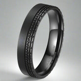 Black titanium ring with textured design on a white background