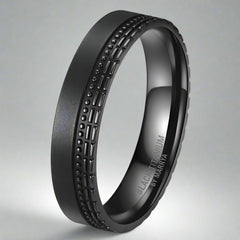 Black titanium ring with textured design on a white background