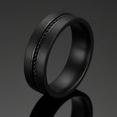 Black ring with textured design on a white background