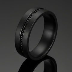Black ring with textured design on a white background