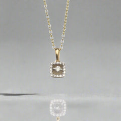 Diamond pendant necklace on a light gray background
