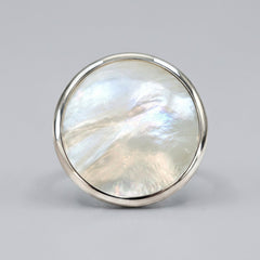 A round silver bezel-set ring featuring a shimmering, iridescent mother-of-pearl inlay, shown on a clean white background.