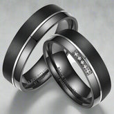 Two black titanium rings with engraved text on a white background