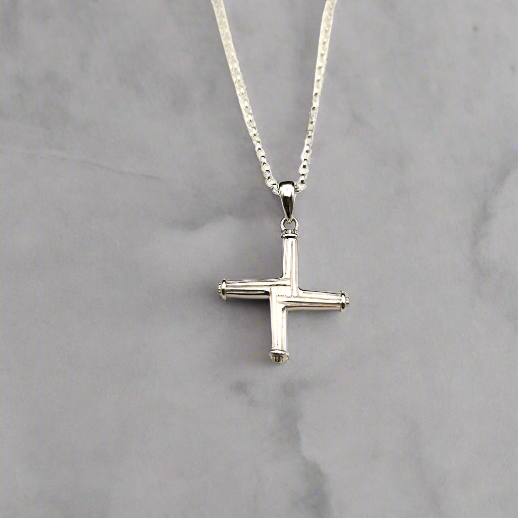 Silver cross necklace on a light gray background