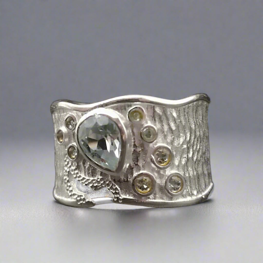Silver ring with gemstones on a dark background