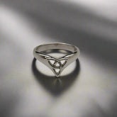 Silver ring with a Celtic knot design on a light gray background