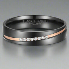 Black titanium ring with rose gold accents and diamond-like stones on a gray background