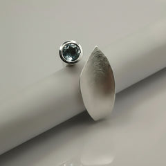 silver ring reminicent of a leaf set with blue topaz