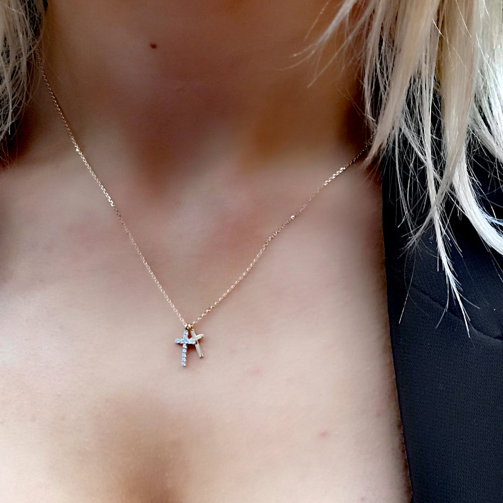 gold cross pendant on womans neck