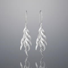 A pair of silver drop earrings with a layered, feather-like wavy design, shown against a plain white background.