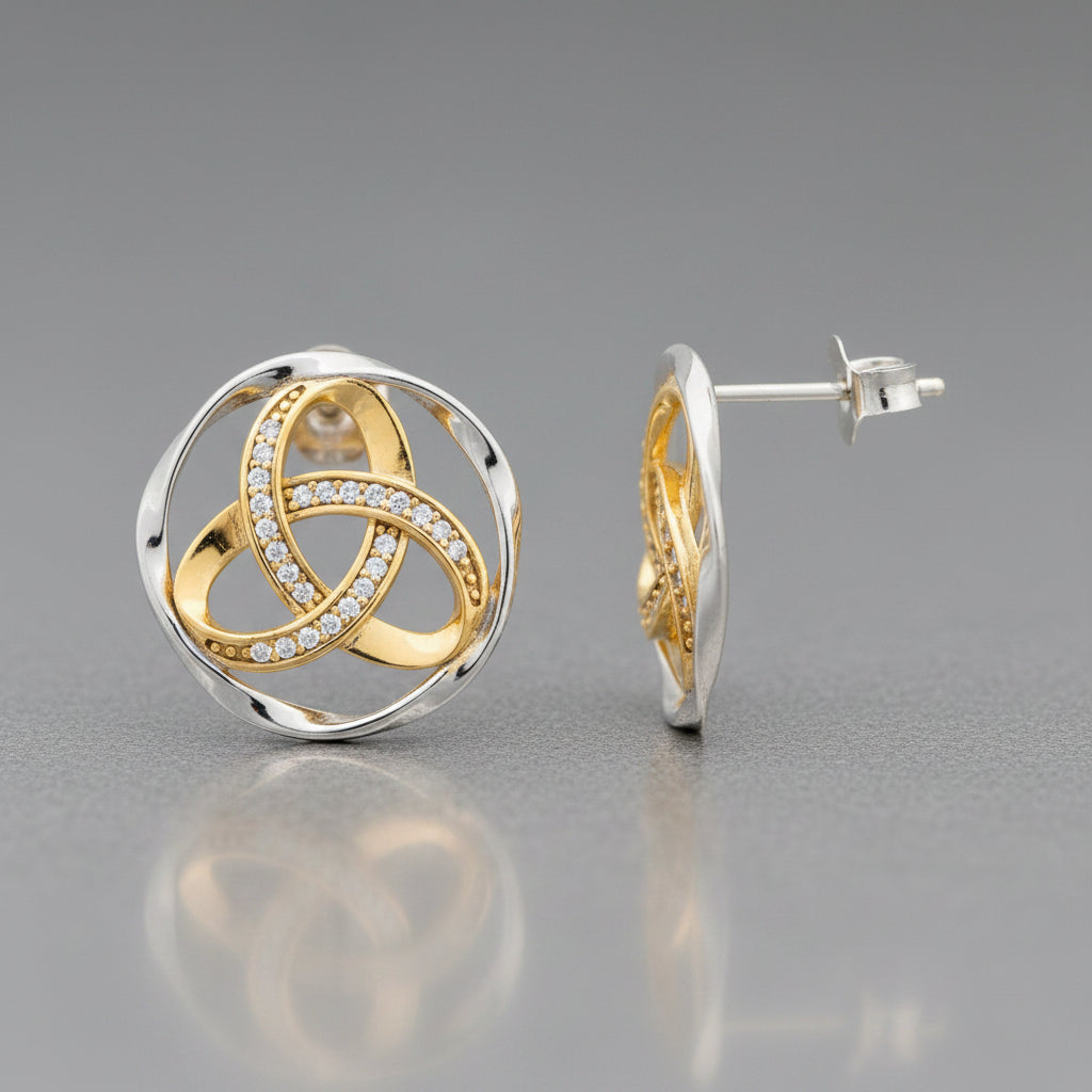 A pair of round interlocking knot stud earrings in yellow gold and white gold, with one earring shown from the front and the other from the side profile. The front earring features a central knot design paved with small clear stones, set within a double-ring circular frame.