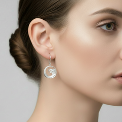 silver drop earrings with wave detail on a models ear