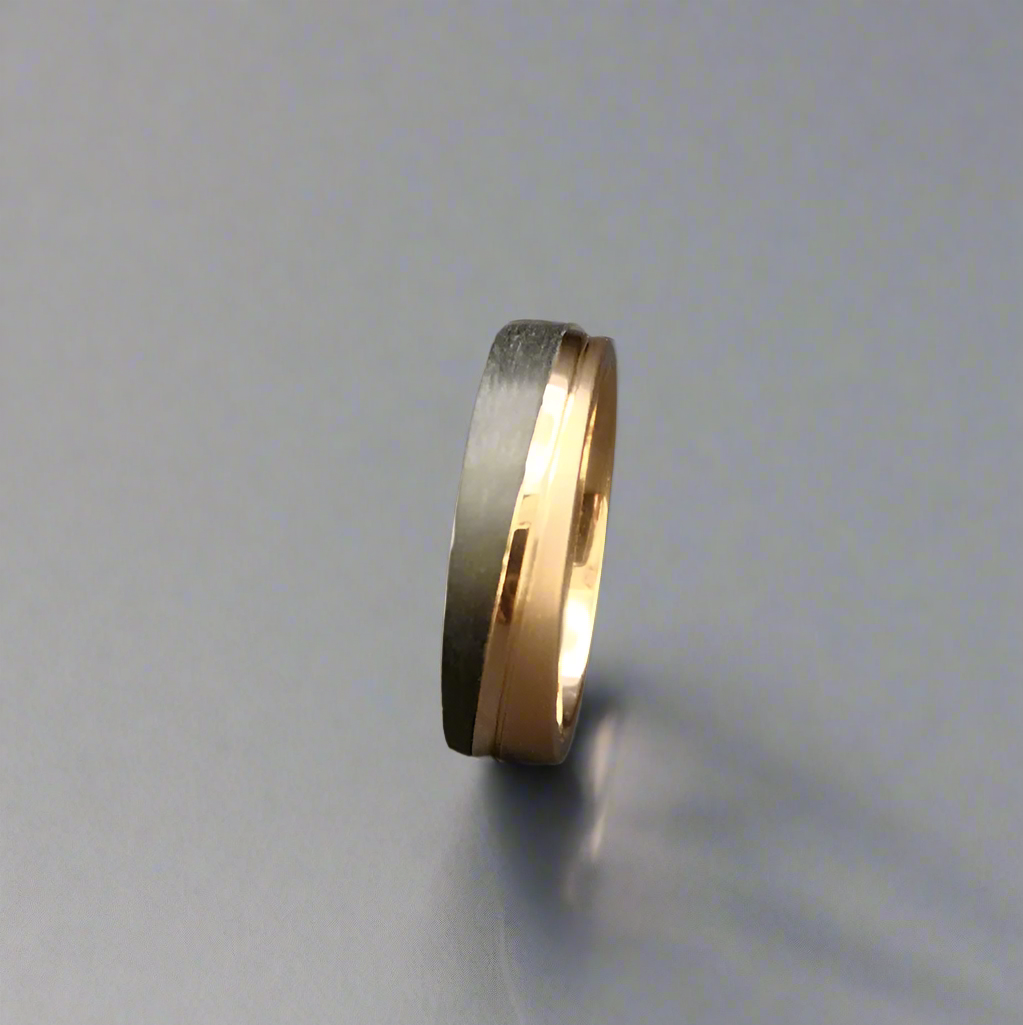 Two-tone ring with gold and black finish on a dark gray background