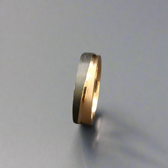 Two-tone ring with gold and black finish on a dark gray background