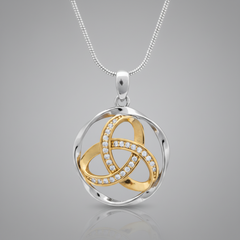 A two-tone silver and gold pendant necklace on a white background. The pendant features a silver-toned circular frame with interwoven gold-toned loops, one of which is lined with small clear stones.